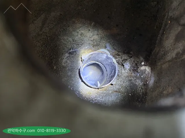 바닥 배수구 안쪽을 조명으로 비춘 근접 사진